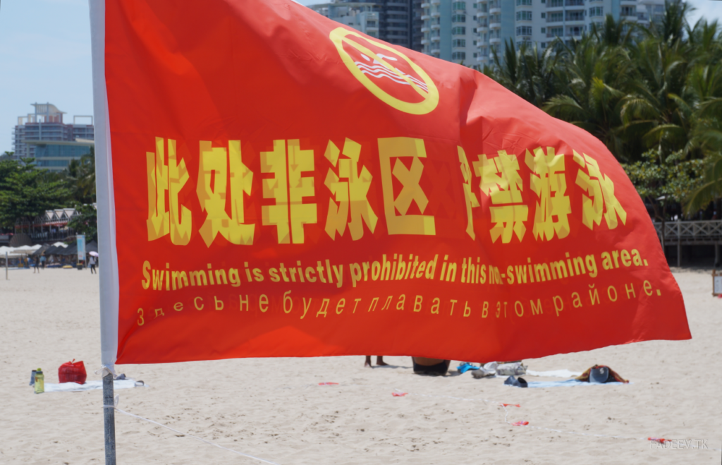 Flag with warning notices on the beach of Da Dong Hai Bay, Sanya, Hainan Island, China.