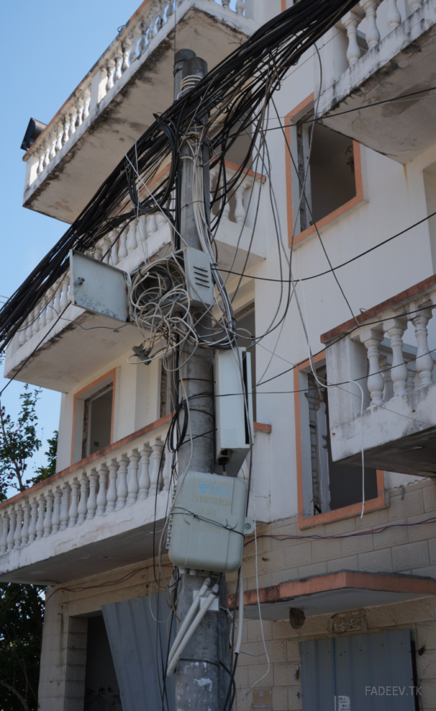 An utility pole in front of a demolition building in an old block. Sanya, Hainan Island, China