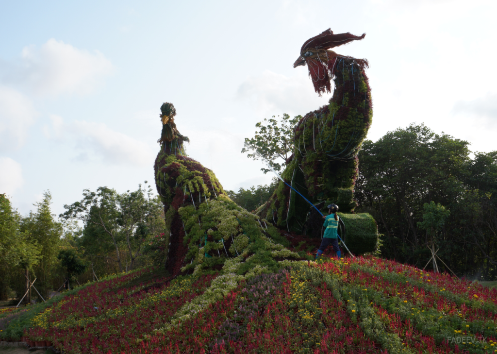 An employee irrigates a flower sculpture in a park in Sanya, Hainan Island, China