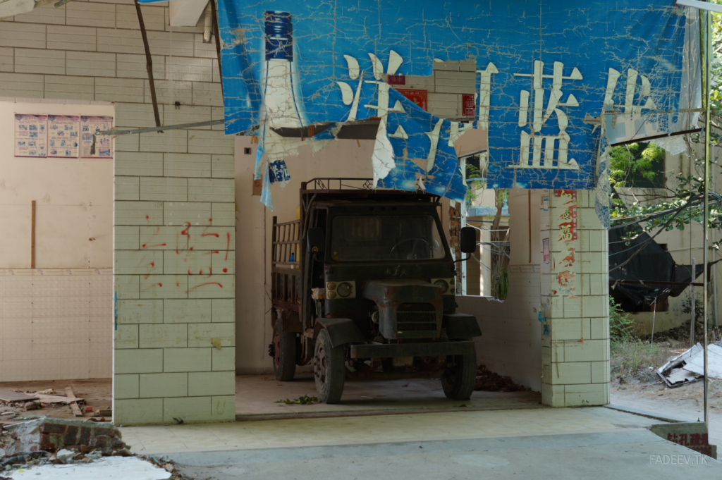 An old truck parked on a block being demolished. Sanya, Hainan Island, China